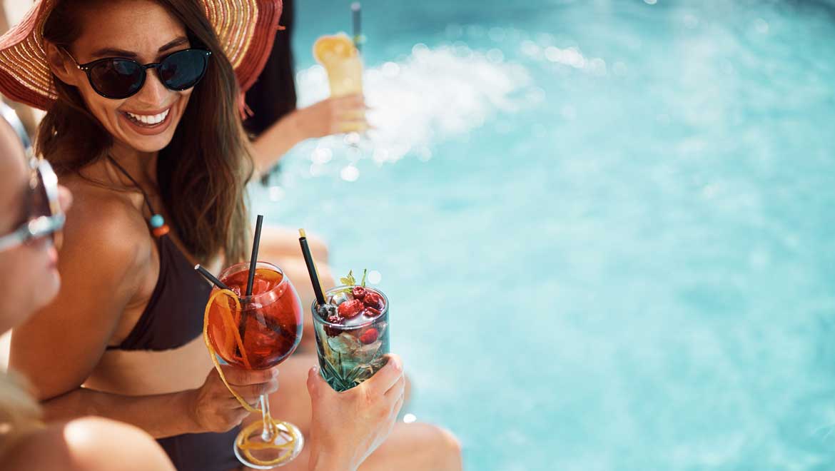 Ladies enjoying cocktails poolside