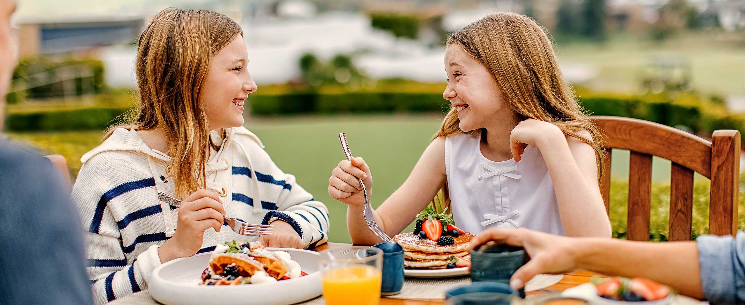 Two little girls eating breakfast