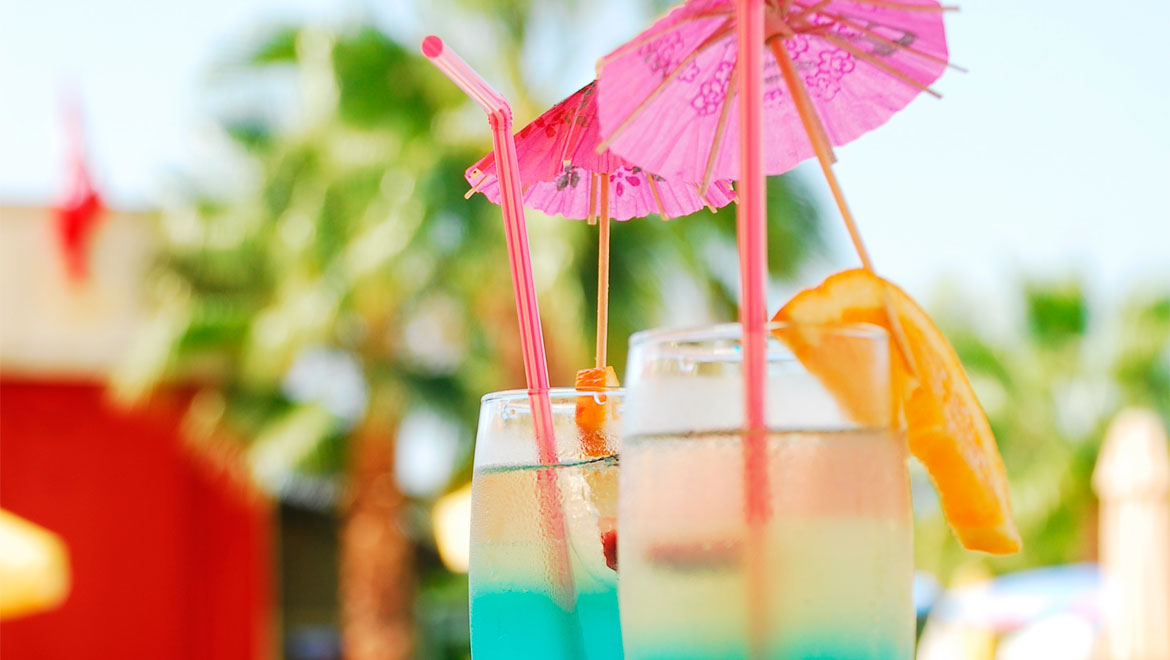 Cocktails with umbrellas and straws