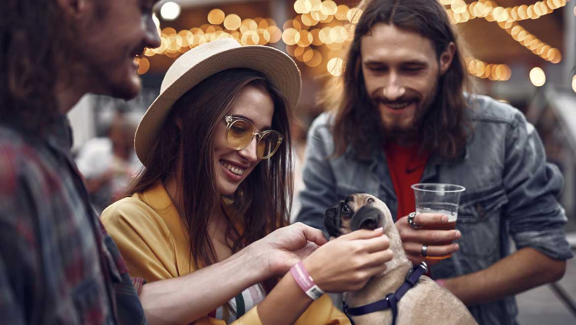 People petting a dog and drinking beer