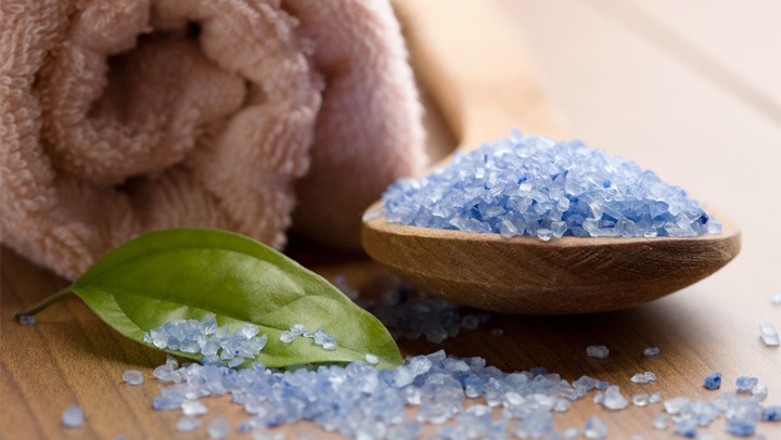 Blue bath salts in wooden dish. 