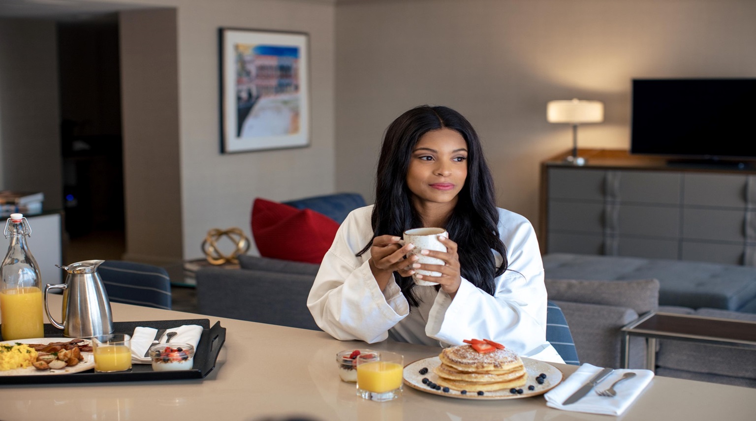 Woman eating breakfast in room.