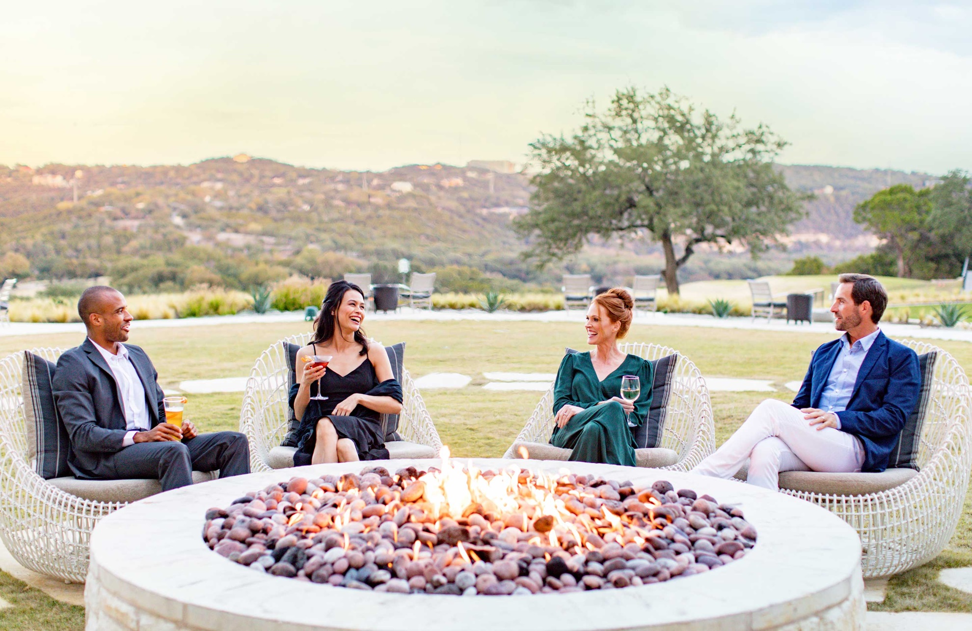 Couples drinking wine by the firepit.