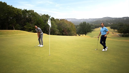 Two golfer on the putting green.