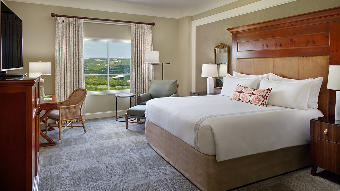 A Premium King Room featuring an activity desk, king bed and lounge chair.