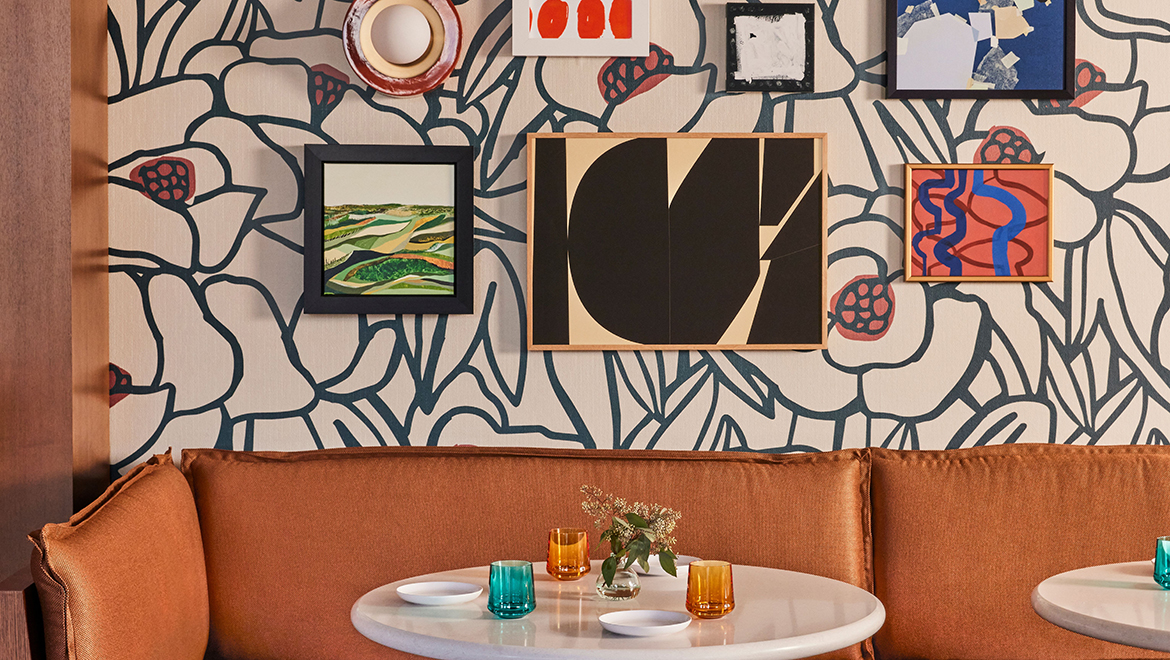  Playful details like whimsical artwork over graphic wallcoverings adorn the energetic Lifted Pool Bar dining room - Omni Boston Hotel at the Seaport