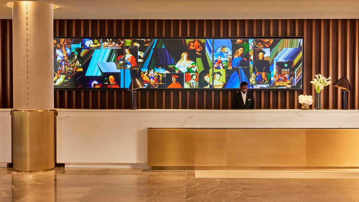 The front desk is anchored by the dynamic "Amagalama" generative video artwork created by Danel Canogar - Omni Boston Hotel at the Seaport