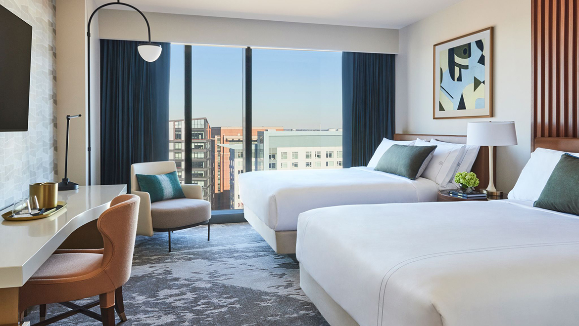 The Double Queen guest rooms in the Patron Tower offer 380 sq. ft. with a sculpturally formed desk with an integrated luggage station - Omni Boston Hotel at the Seaport