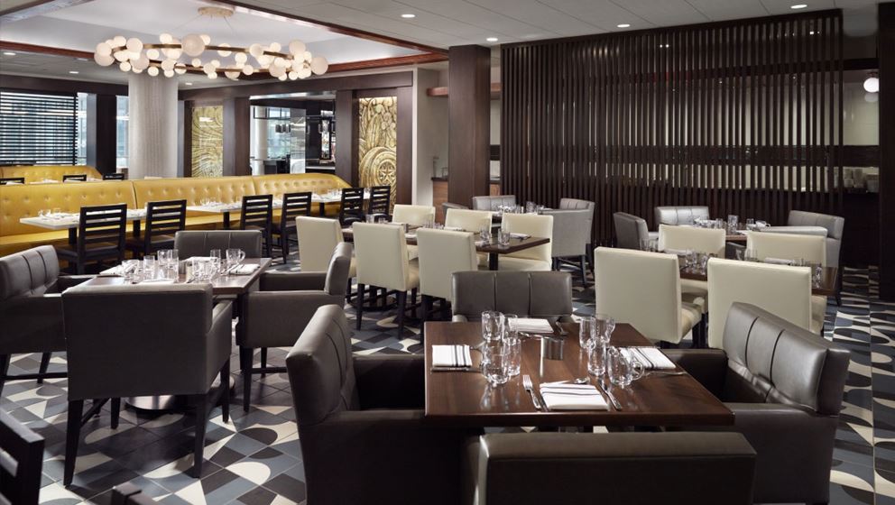 Trade Restaurant and Bar at Omni Charlotte Hotel with dining tables and contemporary furnishings