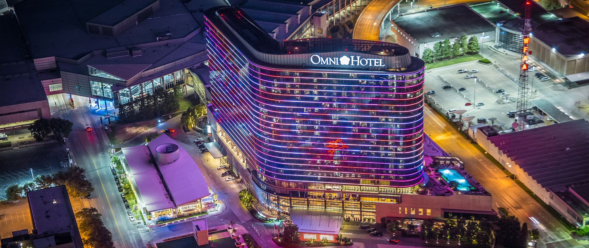 Aerial view of the Omni Dallas Hotel tower lit up at night