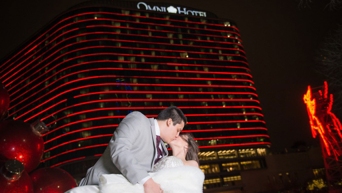 Bride and groom kissing in front of hotel