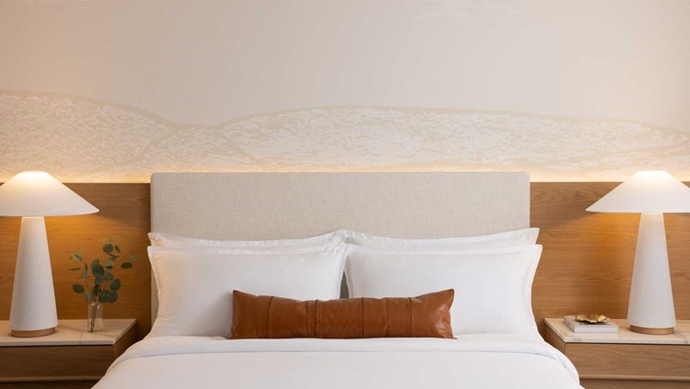 King headboard with side tables and lamps.
