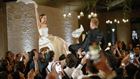 Wedding couple being lifted on chairs.