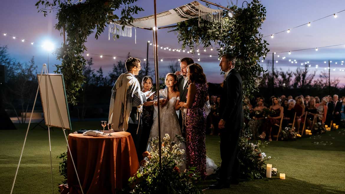 People getting married outdoors at night.