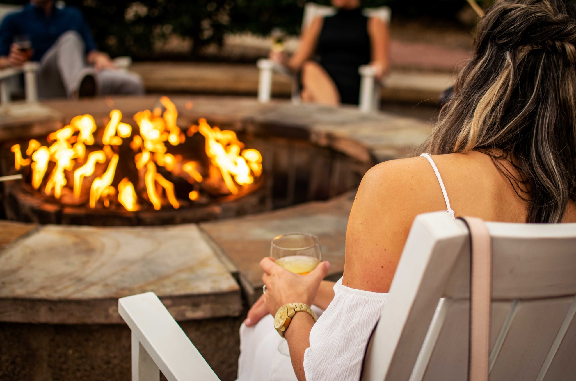 Woman drinking a glass of wine by a firepit at Omni Hilton Head.