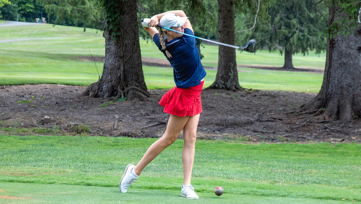 woman swinging a golf club