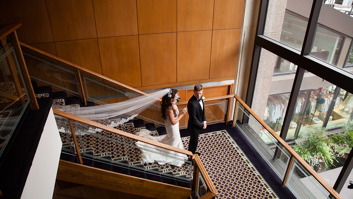 Bride and groom descending stairs.