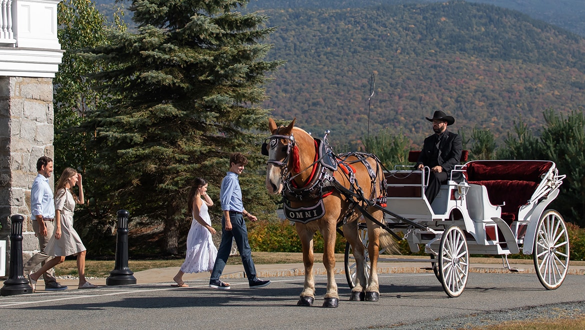 Horse-drawn carriage picking up family at Omni Mount Washington Resort & Spa