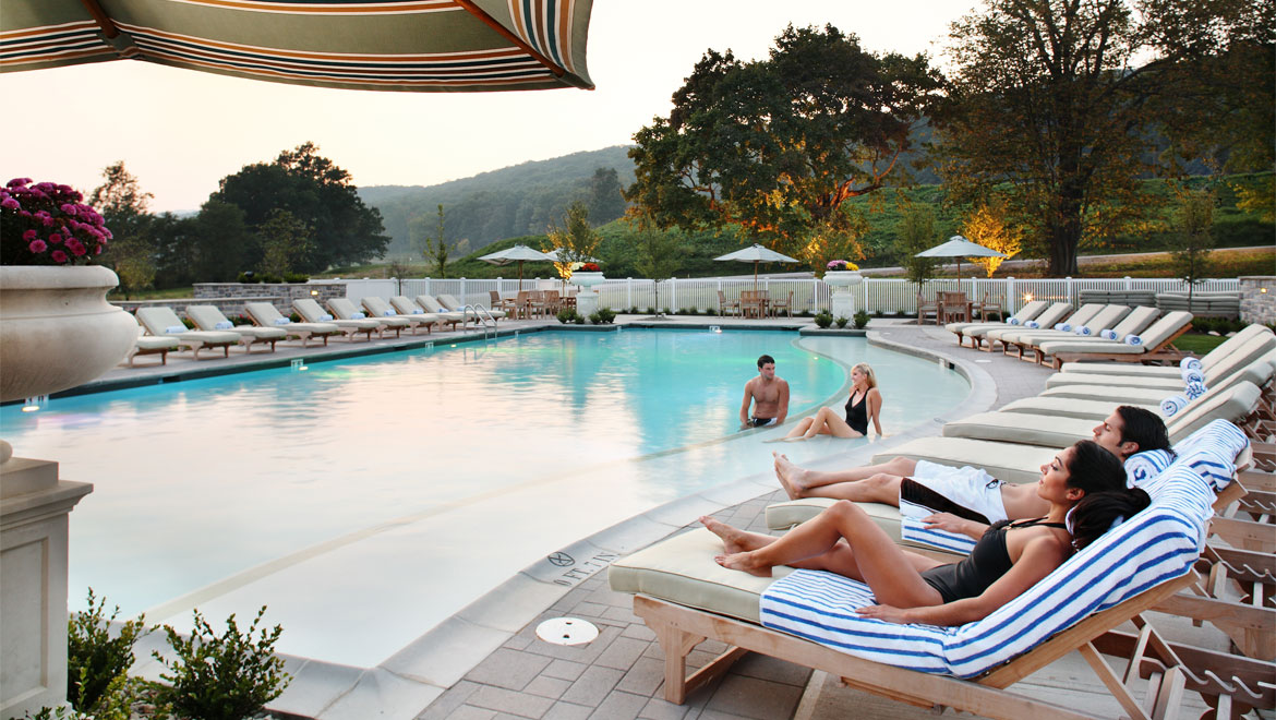 Guests lounging by outdoor pool at Bedford Springs