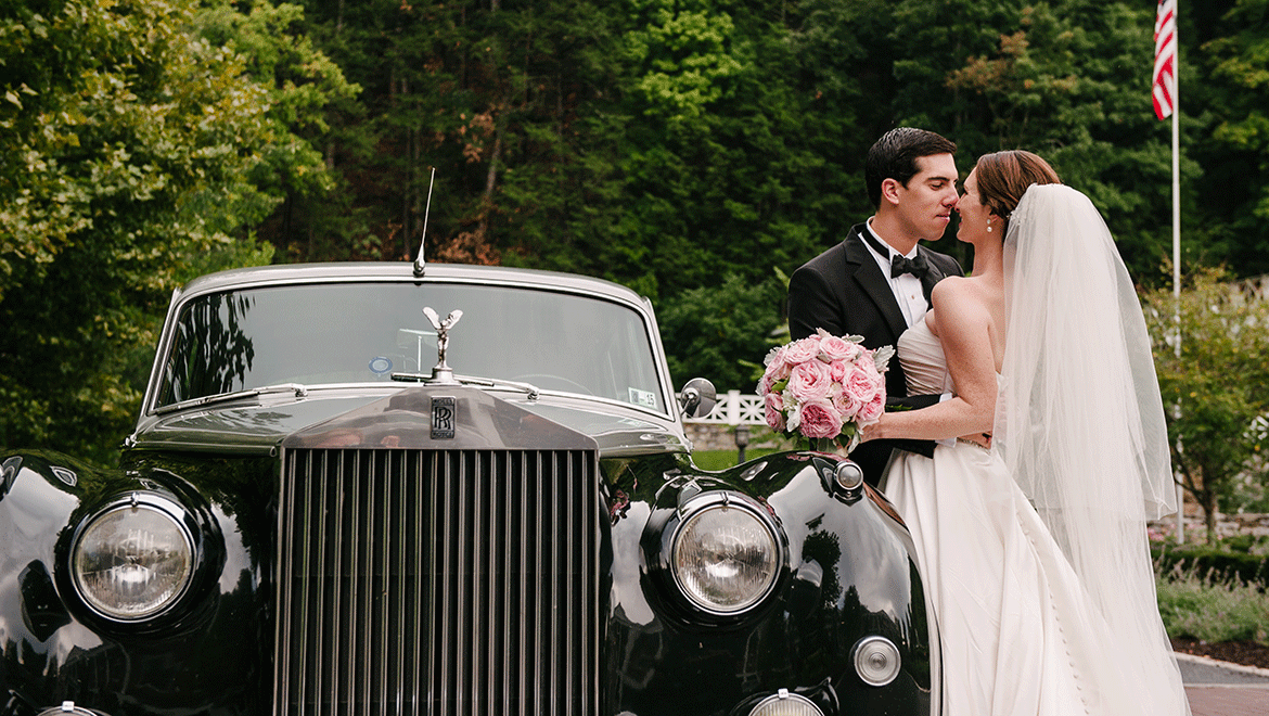 Bride and groom by the getaway car