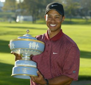 Tiger Woods holding trophy on golf course
