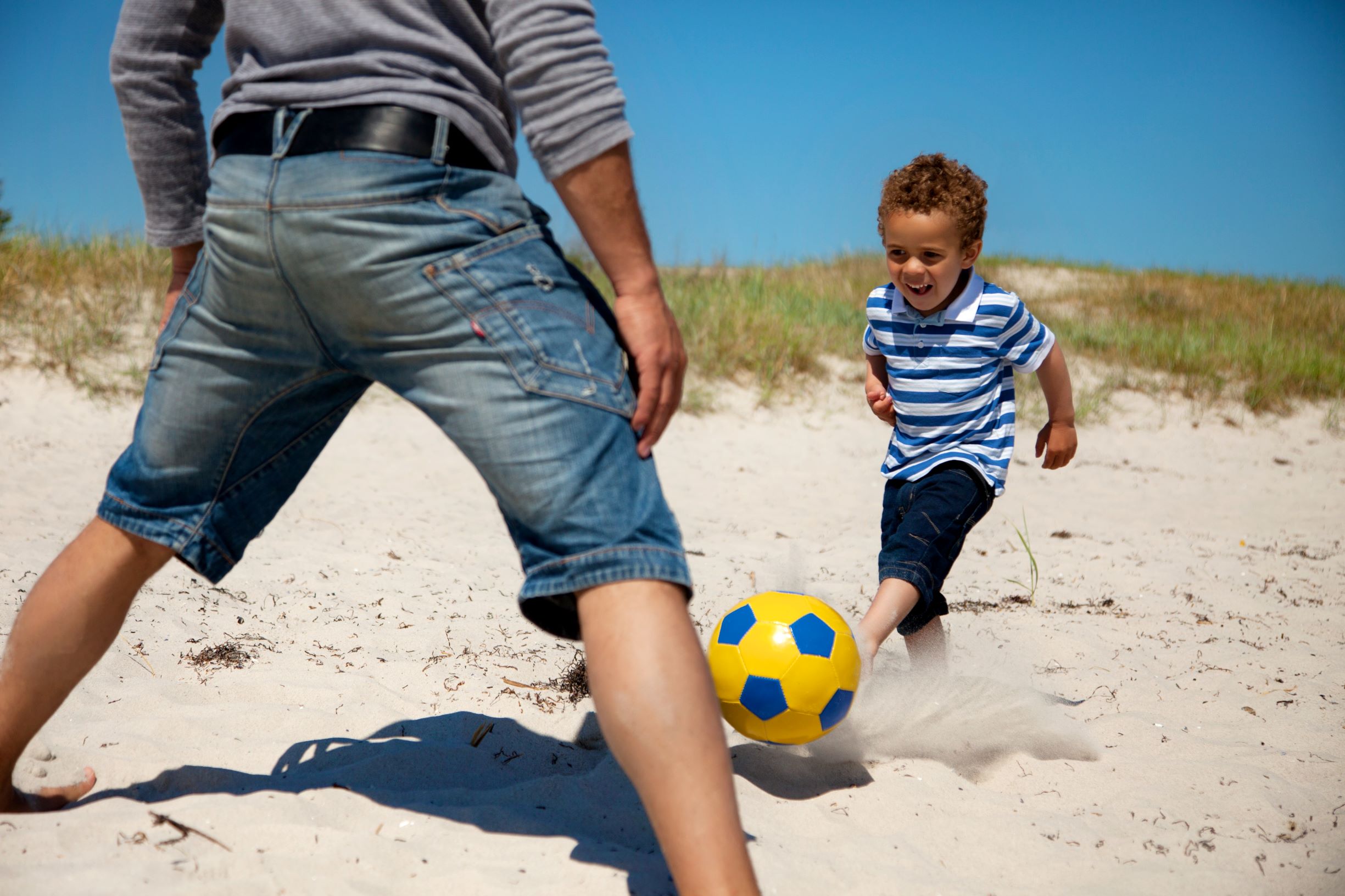 Папы играют в футбол. Папа сын мяч. Отец и сын футбол. Мальчик играет футбол на пляже. С папой в мяч.