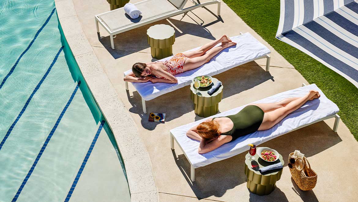 Mom and daughter lounging by the pool